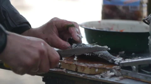 A man cleans a fresh fish with a knife. Video stock 64017273