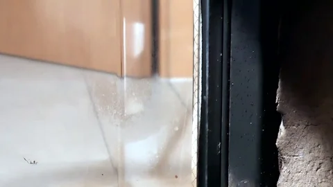 A man cleans glass by a fireplace from soot Видео 100728802