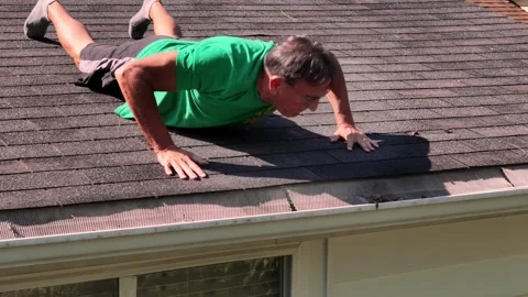 Man Cleans Gutter While Lying on Roof   Stock Footage 345600003