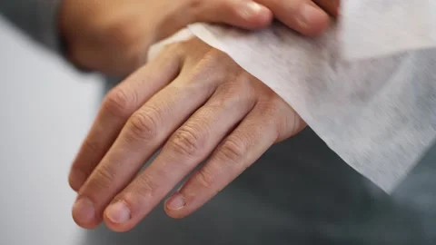 Man cleans hands with moist disposable hygiene wipe Stock Footage 312476957