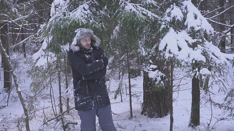 Man in cleans his hands from snow. the man froze. standing in the forest Stock Footage 95587294