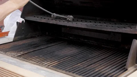 Man cleans inside of bbq grill top and bottom racks 스톡 동영상 121404641