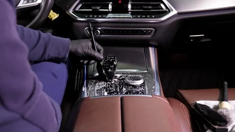 A man cleans the interior and upholstery of a car using a brush for parts. Stock Footage 312441541