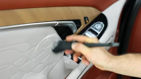 A man cleans the interior of a car with foam and a brush. Stock Footage 314887860
