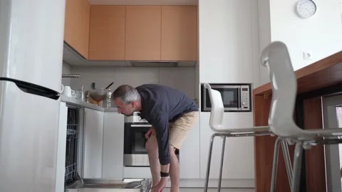 Man cleans up kitchen, puts dishes in dishwasher. Stock Footage 162064047