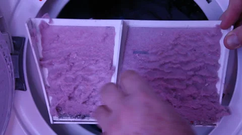 A man cleans lint from laundry dryer Видео 35208594