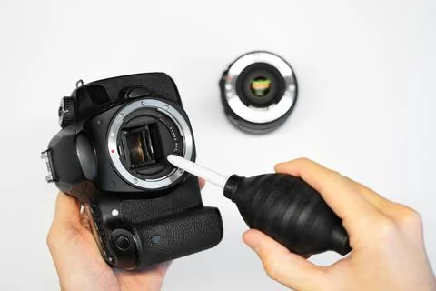 A man cleans the matrix of a SLR camera Stock Photos