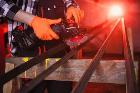 A man cleans metal using an angle grinder. Many sparks Фото