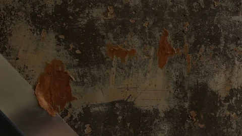 A man cleans the old concrete clay walls of old wallpaper with a spatula close u Stock Footage 104775952