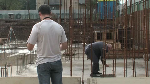 Man cleans the pants leg at a construction site Stock Footage 5165067