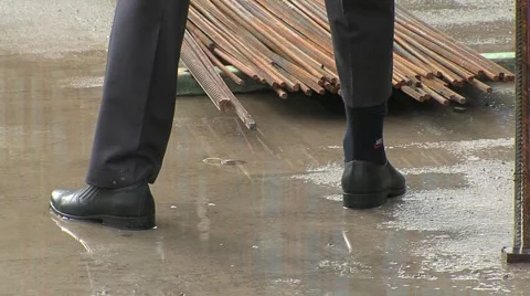 Man cleans the pants leg at a construction site Stock Footage 5165073