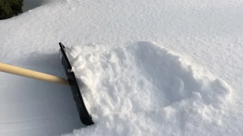 A man cleans the path from snow with a shovel. Snow removal. High quality 4k Stock Footage 233718990