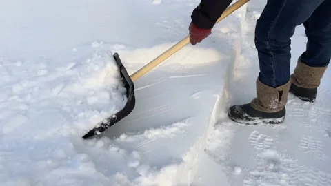 A man cleans the path from snow with a shovel. Snow removal. High quality 4k Stock Footage 233719166