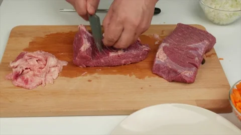 Man cleans a piece of beef from fat and cuts it with a cook knife - healthy d Stock Footage 133714823