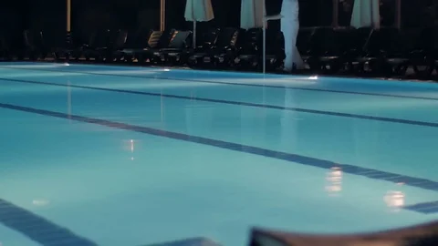The man cleans the pool in the hotel at night Stock Footage 82334170