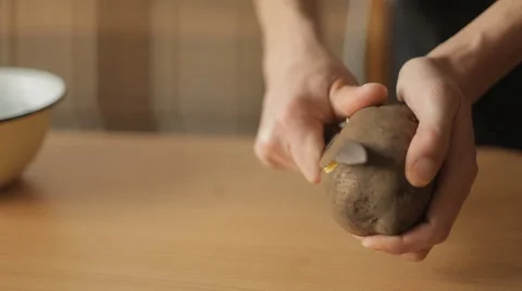 A man cleans the potatoes in the kitchen 스톡 동영상 58891001