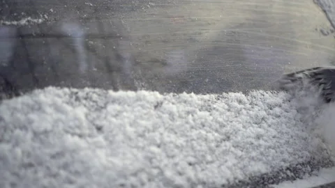 A man cleans the rear window of his car from ice with a scraper close-up. The Stock-Footage 168543920