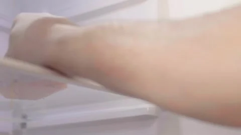 Man cleans up  a refrigerator shelf. Kitchen chores. Man cleaning fridge with sp Stock Footage 305341702