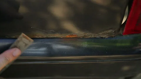 A man cleans rust on a car body with a scraper. Time laps. 库存影片 119334561