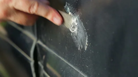 A man cleans rust on a car with a scrape Stock Footage 116792095