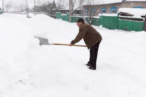 Man cleans snow shovel Stock Photos