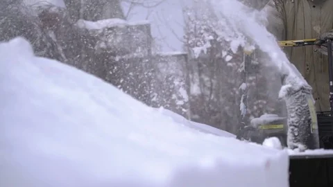 A man cleans snow from sidewalks with snowblower Stock Footage 84666231