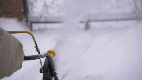 A man cleans snow from sidewalks with snowblower Video stock 84666505