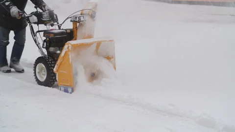 Man cleans the snow with a snow-removing machine Stock Footage 86514357