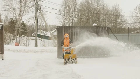 Man cleans snow with a snow thrower. Movement on camera Video stock 125821898