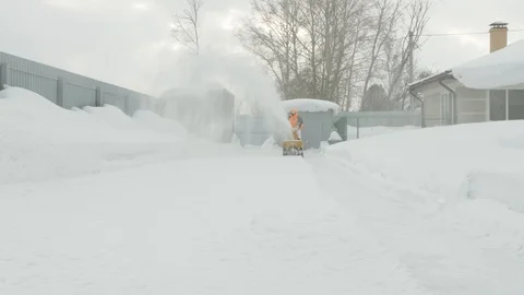 Man cleans snow with a snow thrower Stock Footage 125822725