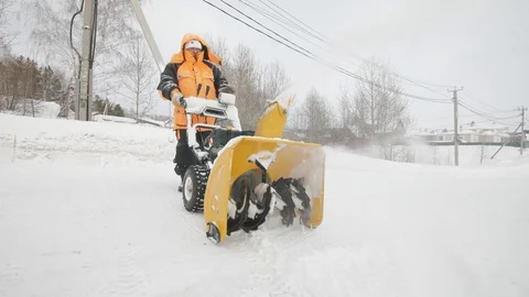 Man cleans snow with a snow thrower Stockbeeldmateriaal 125823682