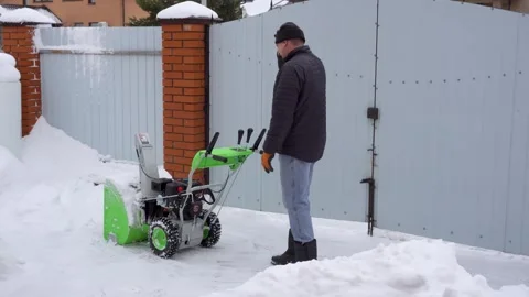 A man cleans snow in the winter in the courtyard of the house,  man cleanin.. Stock Footage 247535876