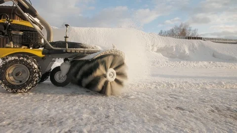 Man cleans snow in the yard with a sweeper in the winter Stockbeeldmateriaal 125824817