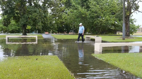 Man cleans storm rain water drain in flooded park Stock Footage 28192519
