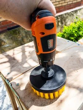 Man cleans surface of bench from dust using brush 库存照片