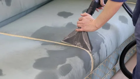 Man cleans surface of couch by washing vacuum with foam solution Stock Footage 276376080