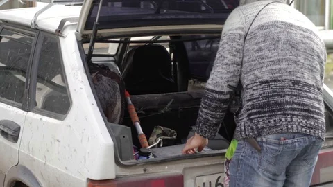 Man cleans in the trunk of a car Stock Footage 71614524