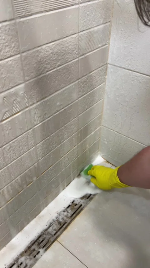 Man cleans wall, drain, floor in shower cabin of bath room with sponge Stock Footage 304761407