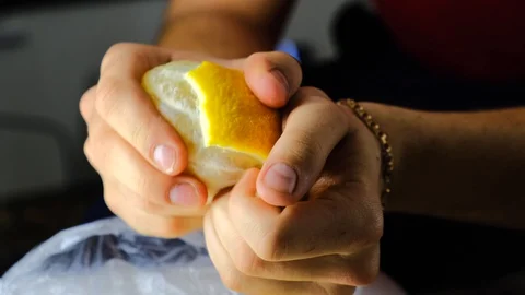 Man cleans yellow lemon with his hands Stock Footage 129688397