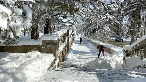 Man clear snow from sidewalk, cleans footpath from snow during blizzard.  Stock Footage 232673892