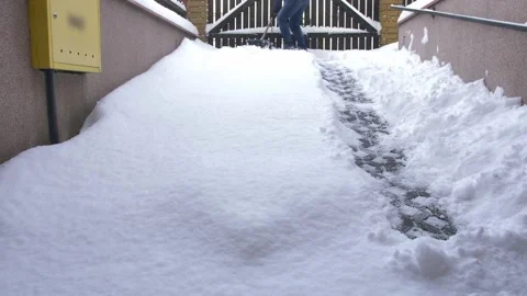 Man Clearing Backyard Pavement of Snow with Snowshovel Time Lapse Stock Footage 147084282
