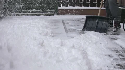 Man Clearing Backyard Pavement of Snow with Snowshovel Stock Footage 147084510