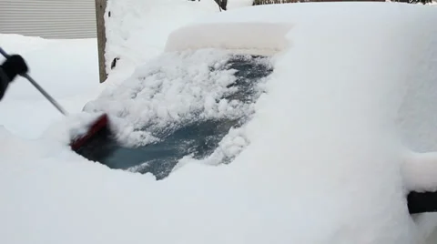Man clearing snow from his car windshield Stock Footage 33605793