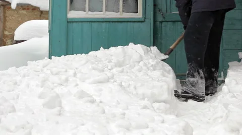 Man clearing snow off with shovel against house Stock Footage 1079673