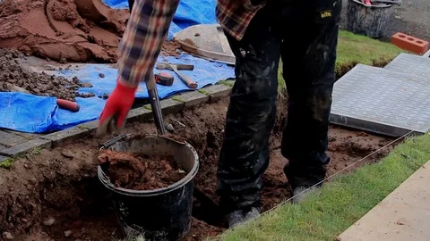 Man clearing soil from trench while building steps Stock Footage 85299509