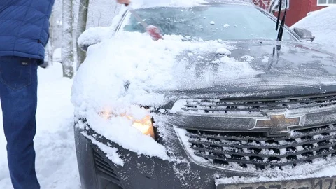 A man clears the car of snow . Much snow. Snow covered the cars. Stock Footage 106636663
