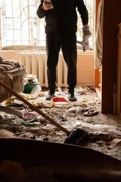 A man clears rubble after a drone exploded under the window of a multi-stor.. Foto stock
