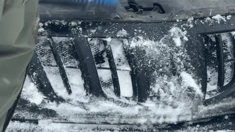 A man clears snow from a car. The car is covered in snow. Stock Footage 328516283