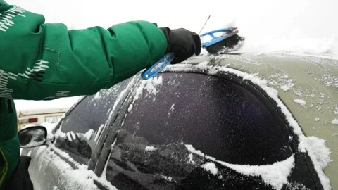 A man clears snow from a car. Ice storm. Car care. Stock Footage 254025618