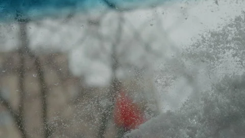 Man clears snow from car windshield on a cold winter day Stock Footage 316488823